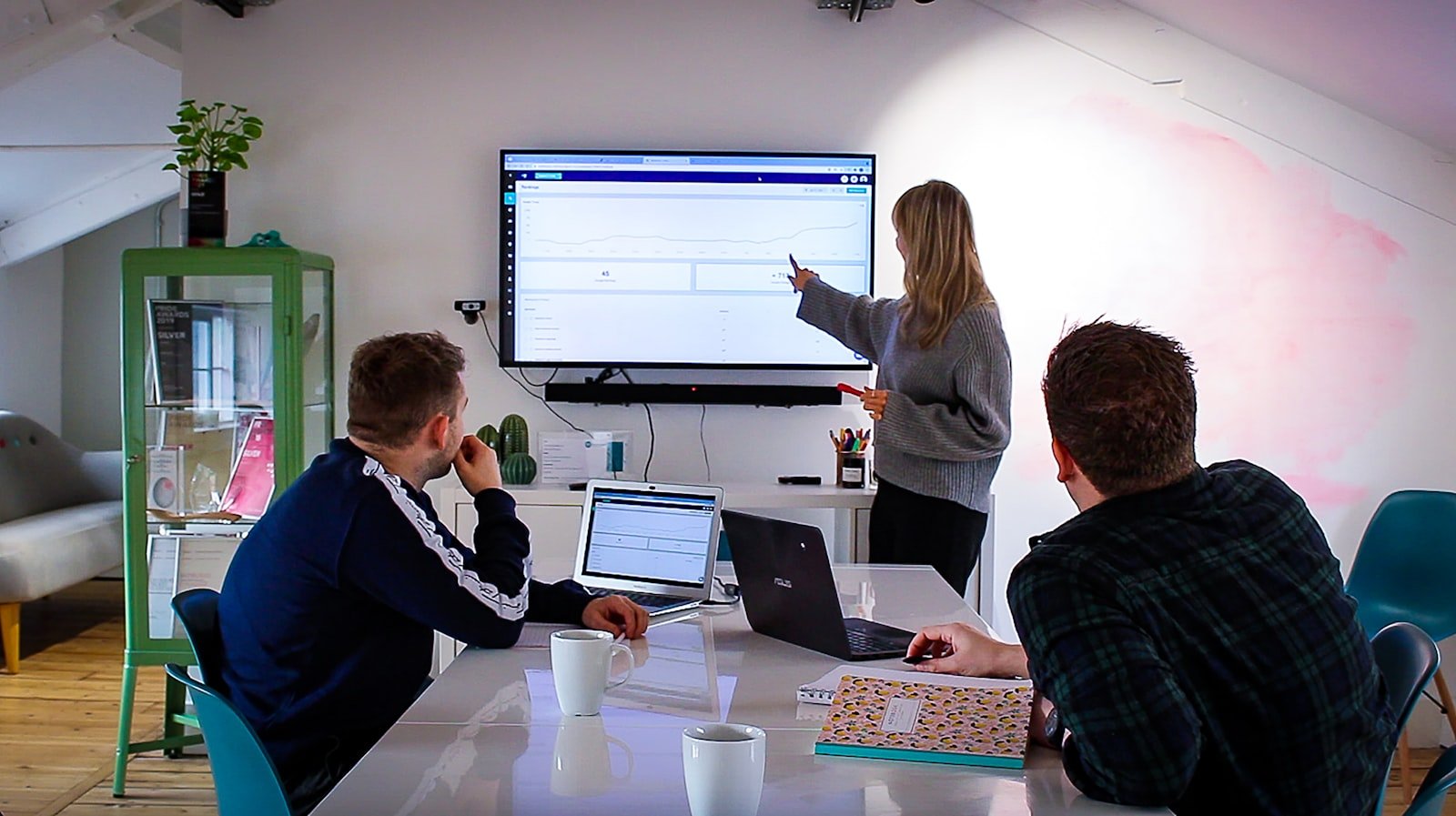 A consultant explaining carbon footprint data to a client in a modern office setting.